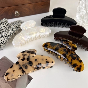 Flat lay of acetate hair claws in assorted colors with France Handmade gold lettering