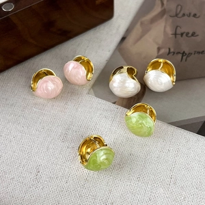 Detailed view of French enamel bean earrings in pink, white, and green with gold plating