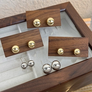 Boucles d'oreilles minimalistes en métal doré et argenté sur support en bois