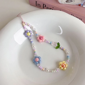 Gros plan d'une dragonne de téléphone perlée tulipe avec fleurs acryliques et perles pastel