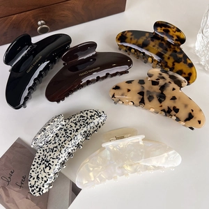 Close-up of six large acetate hair claws in tortoise shell and marble patterns