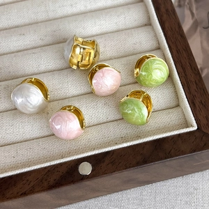 Close-up of French-style pink, white, and green enamel bead hoop earrings in a jewelry box