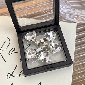 Macro shot of five heart-shaped crystal hairpins with faceted cuts in a display box