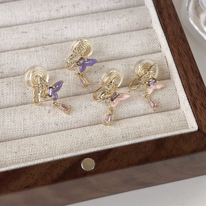 Détail macro de boucles d'oreilles papillon avec émail et zircons dans un coffret à bijoux