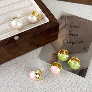 Detail of French pink drip glaze huggie earrings in gold finish and marble texture