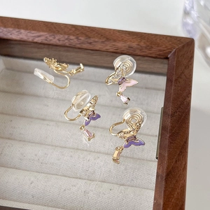 Détail de boucles d'oreilles clips papillon avec zircon et coussinets en silicone