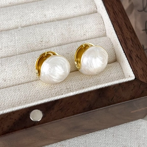 Detailed close-up of French pink enamel stud earrings resting in a premium jewelry box