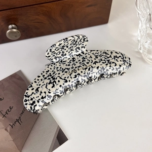 Close-up of black and white acetate hair claw clip with golden France handmade logo