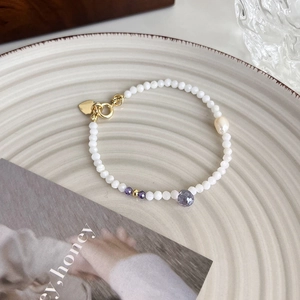 Détail du bracelet en perles avec perle d'eau douce et pierres précieuses facettées