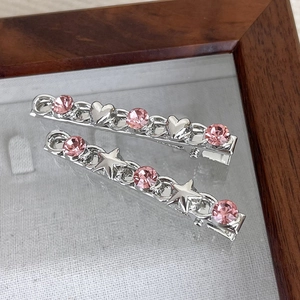 Detail view of pink rhinestone heart and star hair clips on a silver alloy base