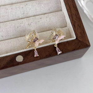 Gros plan détaillé de boucles d'oreilles papillon dorées avec zircon rose et émail