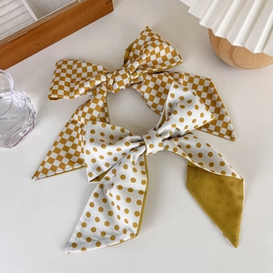 Detail of mustard yellow polka dot and checkerboard satin bow scarves for hair and bags