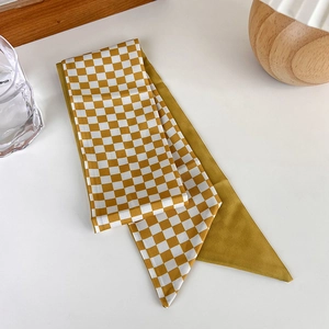 Detail of yellow checkered silk scarf tied on a glass cup as a stylish decor
