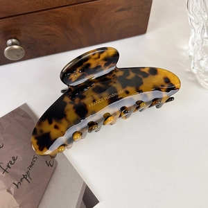 Detail of tortoise shell hair claw clip featuring gold FRANCE Handmade lettering