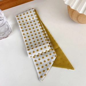 Detail of yellow polka dot silk scarf and headband with elegant satin texture finish