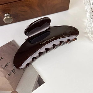 Detail of large dark brown acetate hair claw clip with France Handmade gold lettering