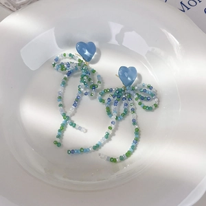Boucles d'oreilles nœud en perles avec cœurs bleus et longues franges colorées