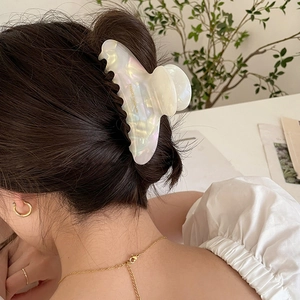 Elegant iridescent white acetate claw clip for women's hairstyle in outdoor light