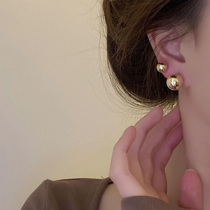 Boucles d'oreilles boules dorées polies minimalistes en petites et grandes tailles sur modèle