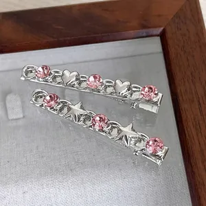 Silver metal hair clips with pink rhinestone heart and star patterns on display