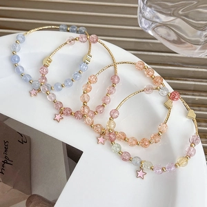 Detail view of a four-piece beaded bracelet set with star pendants on a ceramic plate