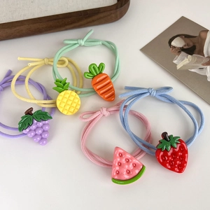 Vue détaillée de cinq chouchous colorés avec des motifs de fruits en résine et de fraises