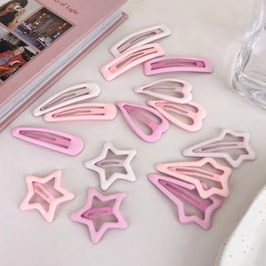 Close-up of star and heart shaped pink gradient matte hair clips set on a table