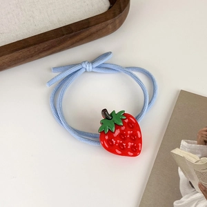 Gros plan d'un élastique bleu avec un pendentif détaillé en forme de fraise en résine