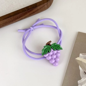 Gros plan sur l'élastique à cheveux violet avec décorations de raisins mignons
