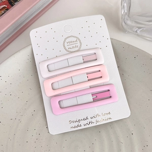 Detail showing a set of three matte pink gradient star hair clips on white cardstock