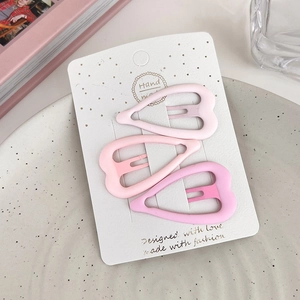 Three gradient pink heart-shaped hair clips with matte finish on a white display card
