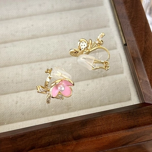 Detail of pink enamel flower ear clips with zircon accents and soft silicone pads