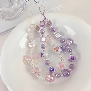 Sweet lavender and pink beaded phone charms with cute bows and aurora pearls in a ceramic dish