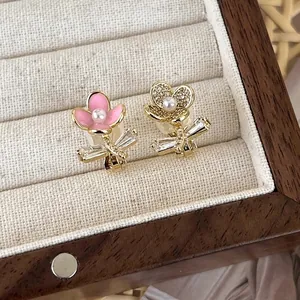 Asymmetric zircon flower earrings with pink enamel and white pearls in a jewelry box