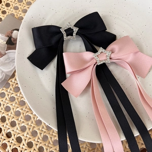 Pink and black satin bow hair clips with sparkling star pendants for a sweet style