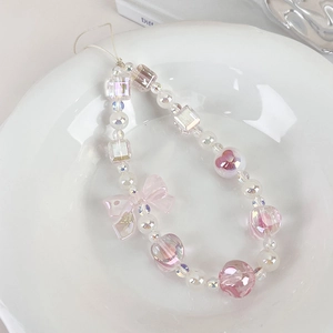 Close-up of a sweet lavender and pink beaded phone charm with a bow on a white plate