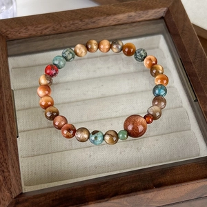 Macro view of multi-color natural stone beads bracelet on a vintage wooden jewelry box