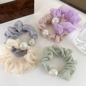 Set of four pastel chiffon scrunchies with large iridescent pearls on a white background