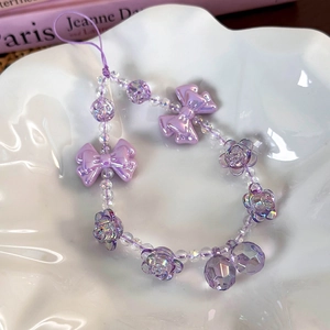 Detailed macro view of purple candy-style beaded phone strap with iridescent bow and roses