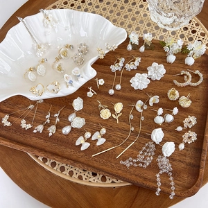 Detail view of floral shell earrings with pearls and long tassel vintage designs