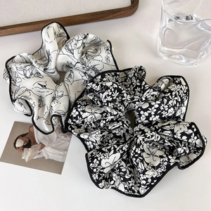Detail of French vintage ink-style floral scrunchies with elegant black piped edges and texture