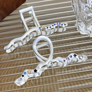 Detail of silver alloy star hair claws with colorful rhinestones and black enamel stars