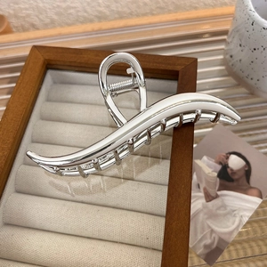 Detailed view of silver wave-shaped metal shark hair claw clip for thick hair