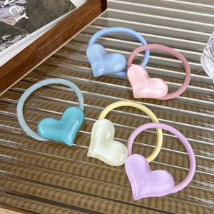Detail view of five colorful heart-shaped elastic hair ties with pearlescent resin finish