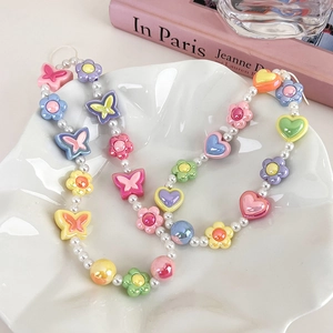 Chaîne de téléphone perlée colorée avec perles blanches, papillons, fleurs et cœurs