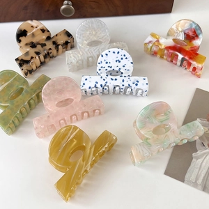 Flat lay of diverse acetate hair claws with marble and leopard patterns on white background