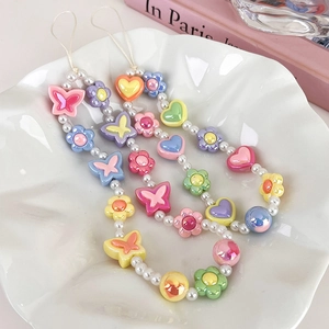 Cordons de téléphone en perles pastel avec motifs papillon et fleur dans un plat chic
