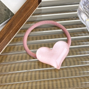 Close-up of pink heart pendant hair tie with gradient resin finish and elastic ribbon