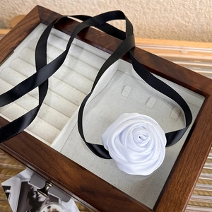 Elegant white satin rose choker necklace with long black silk ribbon in a vintage jewelry box