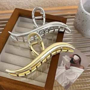 Minimalist metallic crescent hair claw clips in silver and gold high-gloss finish